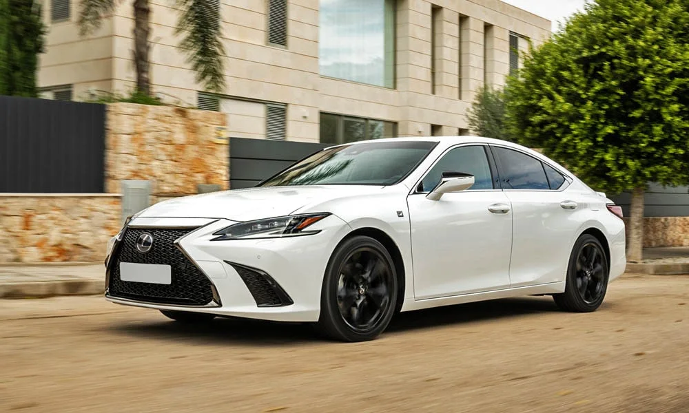 Фото Lexus ES 350 — вид спереди, фото 10. Кузов в белом цвете: рисунок оптики и решётки задаёт узнаваемое «лицо» модели. Рисунок ходовых огней — подпись модели, по нему её узнают в потоке Lexus ES 350 — вид спереди, фото 10