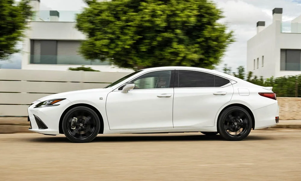 Фото Lexus ES 350 — вид сбоку, фото 2. Сбоку читаются линия остекления и характер выштамповок на белом кузове. Длинная база — простор второго ряда; короткие свесы упрощают парковку Lexus ES 350 — вид сбоку, фото 2