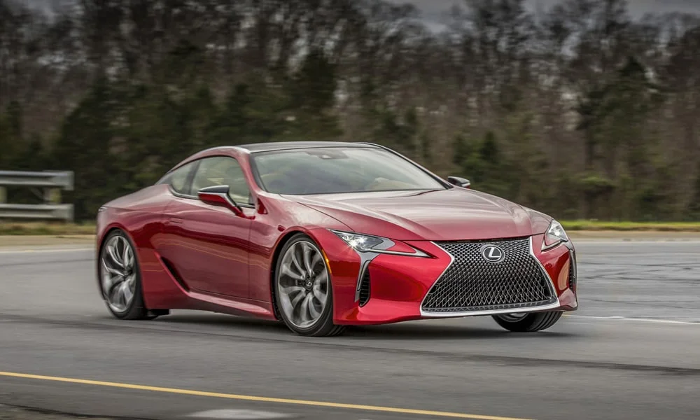 Фото Lexus LC 500 — вид спереди, фото 6. Красный кузов, строгая симметрия оптики — базовый ракурс знакомства с дизайном. Дневные ходовые огни включаются автоматически с запуском Lexus LC 500 — вид спереди, фото 6