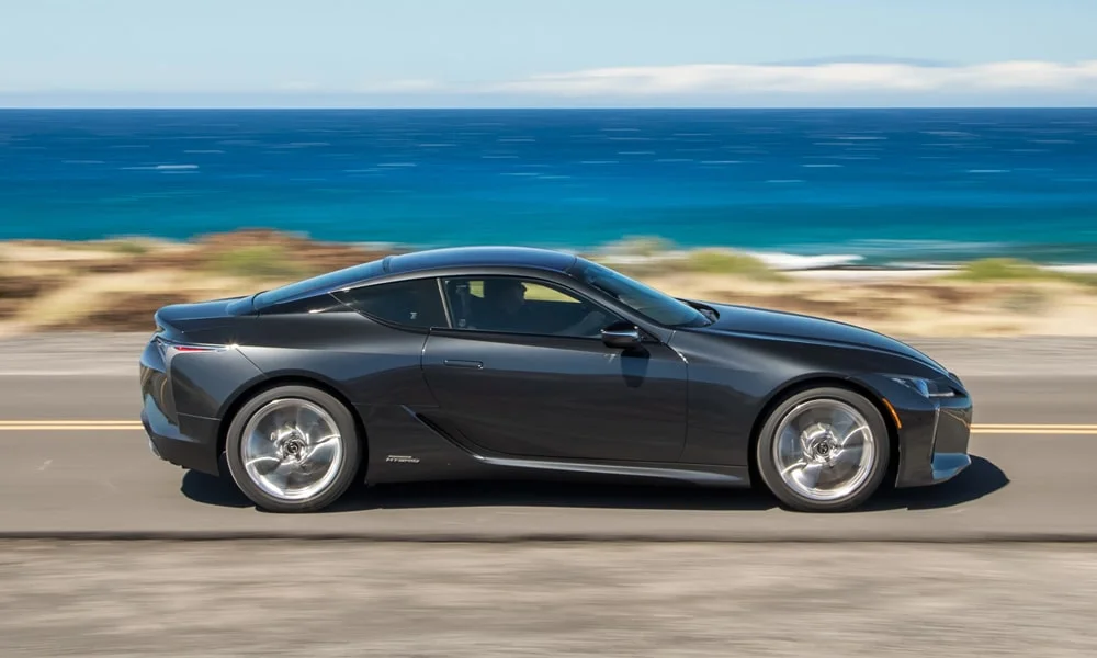 Фото Lexus LC 500 — вид сбоку. Профиль кузова: колёсная база, свесы и линия остекления. Длинная база — простор второго ряда; короткие свесы упрощают парковку Lexus LC 500 — вид сбоку
