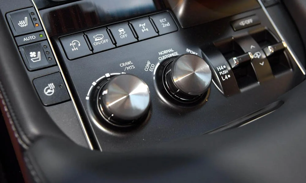 Фото Lexus LX 450d — блок климат-контроля. Физические клавиши температуры и обдува. Раздельные зоны позволяют водителю и пассажиру выбрать свою температуру Lexus LX 450d — блок климат-контроля