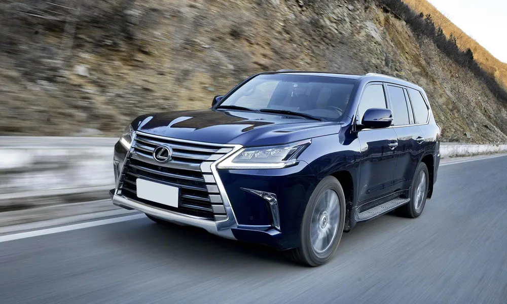 Фото Lexus LX 450d — вид спереди, фото 4. Кузов в синем цвете: рисунок оптики и решётки задаёт узнаваемое «лицо» модели. Рисунок ходовых огней — подпись модели, по нему её узнают в потоке Lexus LX 450d — вид спереди, фото 4