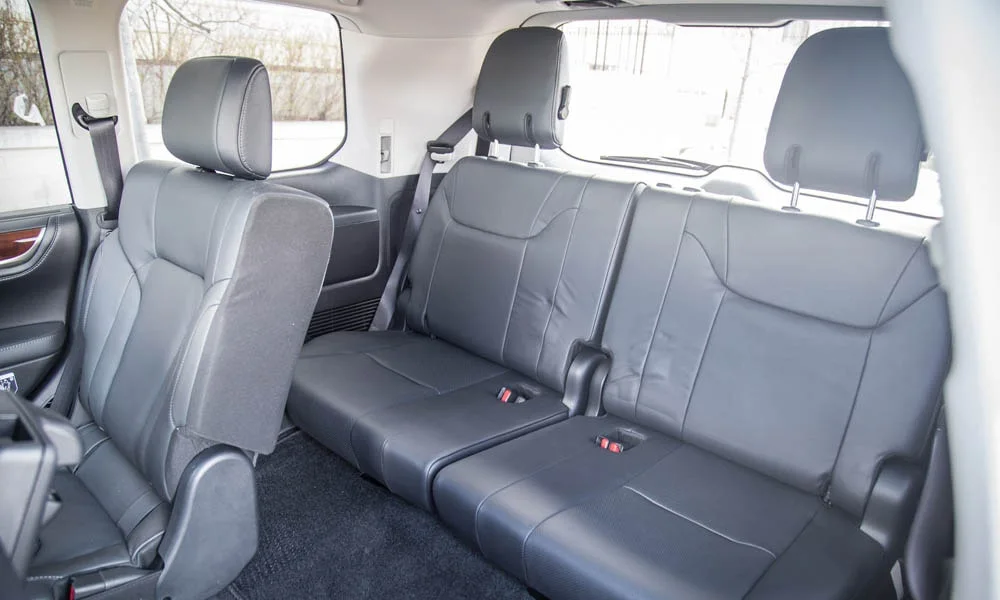 Фото Lexus LX 570 — задние сиденья, фото 2. Задний диван в гладкой коже: посадка и центральный подлокотник. Крепления ISOFIX для детских кресел — в основании спинки Lexus LX 570 — задние сиденья, фото 2