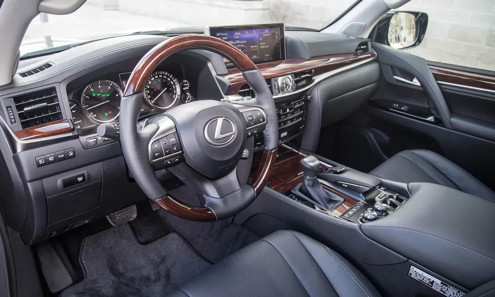 Фото Lexus LX 570 — руль. Обшивка обода и компоновка спиц крупным планом. Обогрев обода — опция, которую оценят зимой Lexus LX 570 — руль
