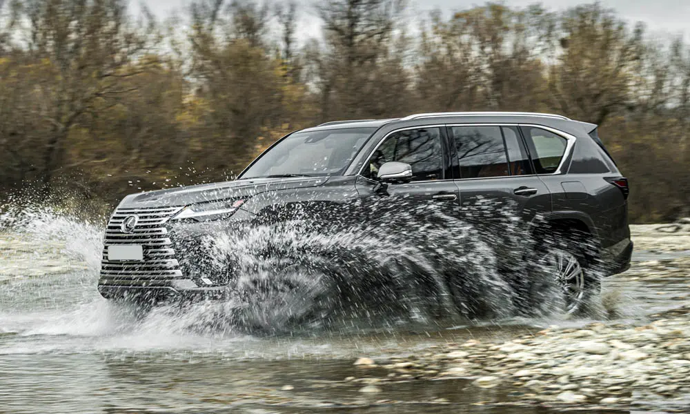 Фото Lexus LX 600 (2022) — вид спереди, фото 5. Анфас: пропорции капота, посадка кузова и графика ходовых огней. Рисунок ходовых огней — подпись модели, по нему её узнают в потоке Lexus LX 600 (2022) — вид спереди, фото 5