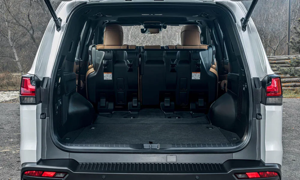 Фото Lexus LX 600 (2022) — багажник, фото 3. Грузовой отсек с открытой дверью: погрузочная высота и ширина проёма. Спинки второго ряда складываются и расширяют отсек под длинные грузы Lexus LX 600 (2022) — багажник, фото 3