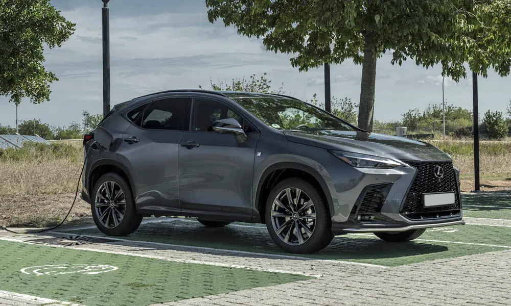 Фото Lexus NX 450h (2024) — вид спереди, фото 2. Серый кузов, строгая симметрия оптики — базовый ракурс знакомства с дизайном. Рисунок ходовых огней — подпись модели, по нему её узнают в потоке Lexus NX 450h (2024) — вид спереди, фото 2