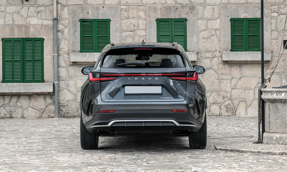 Фото Lexus NX 450h (2024) — вид сзади, фото 3. Серый кузов сзади — фонари и бампер определяют ночной образ модели. Светодиодная полоса или раздельные секции — задняя оптика стала главным украшением кормы Lexus NX 450h (2024) — вид сзади, фото 3
