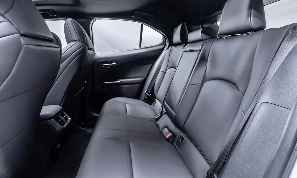Фото Lexus UX 200 (2024) — задние сиденья. Посадка второго ряда: подголовники и подлокотник. Плоский пол упрощает посадку втроём Lexus UX 200 (2024) — задние сиденья
