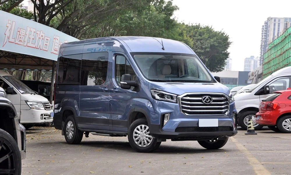 Фото Maxus V90 (2024) — вид спереди, фото 6. Синий кузов, строгая симметрия оптики — базовый ракурс знакомства с дизайном. Рисунок ходовых огней — подпись модели, по нему её узнают в потоке Maxus V90 (2024) — вид спереди, фото 6