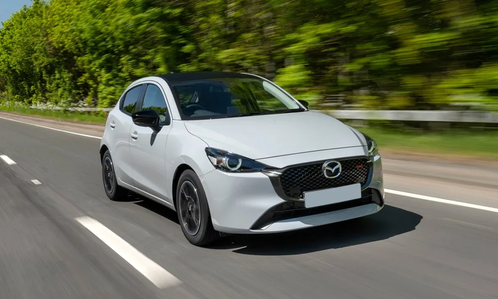 Фото Mazda 2 (2024) — вид спереди, фото 6. Анфас: пропорции капота, посадка кузова и графика ходовых огней. Дневные ходовые огни включаются автоматически с запуском Mazda 2 (2024) — вид спереди, фото 6