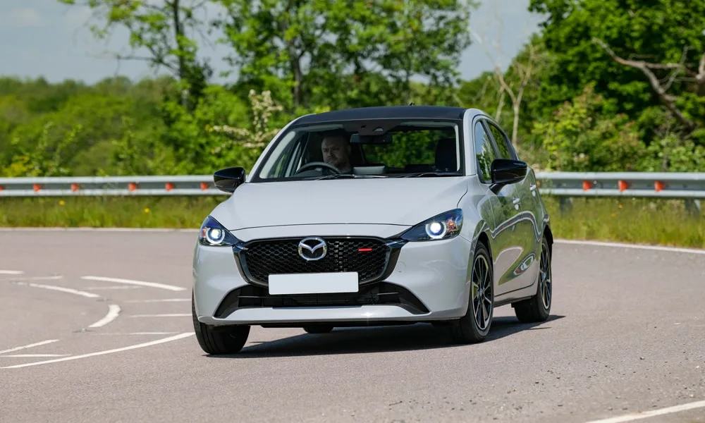 Фото Mazda 2 (2024) — вид спереди, фото 7. Анфас: пропорции капота, посадка кузова и графика ходовых огней Mazda 2 (2024) — вид спереди, фото 7