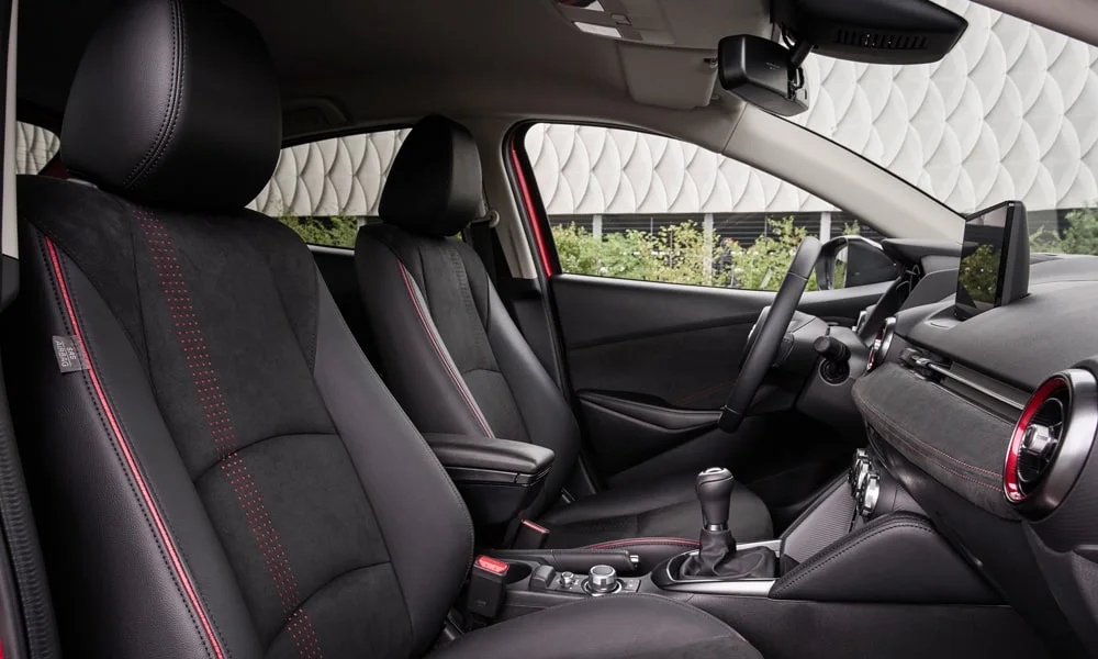 Фото Mazda 2 (2024) — интерьер. Общий план салона: архитектура панели, консоль и кресла Mazda 2 (2024) — интерьер
