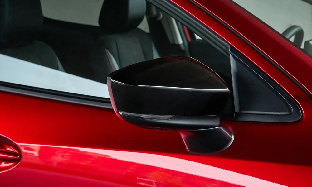 Фото Mazda 2 (2024) — наружное зеркало. Корпус с повторителем поворота; у ряда версий здесь же камера кругового обзора. Обогрев и электроскладывание зеркал управляются с водительской двери Mazda 2 (2024) — наружное зеркало