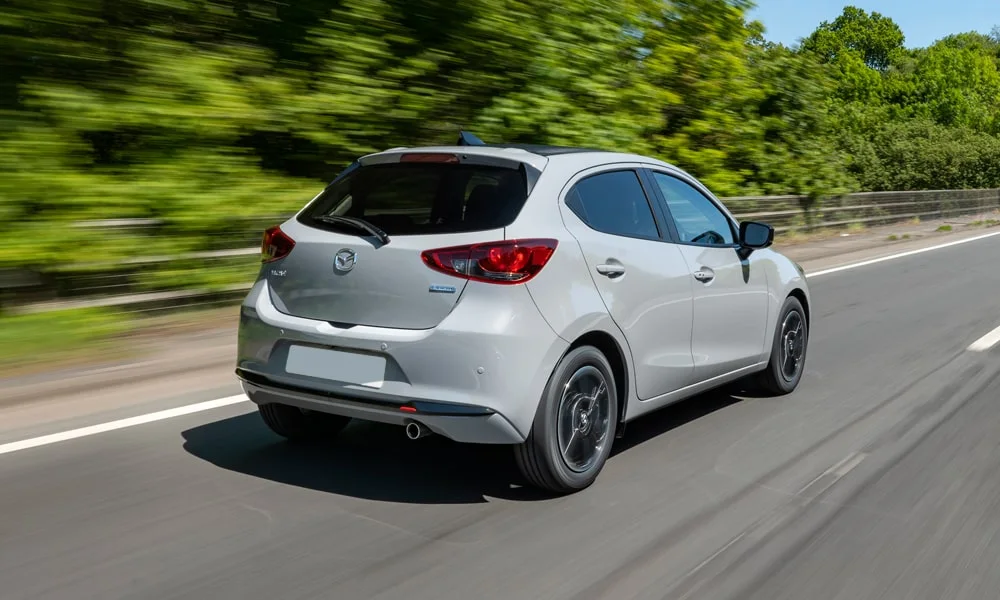 Фото Mazda 2 (2024) — вид сзади, фото 4. Графика фонарей, бампер и оформление пятой двери. Насадки выхлопа или их имитация внизу бампера различают версии Mazda 2 (2024) — вид сзади, фото 4