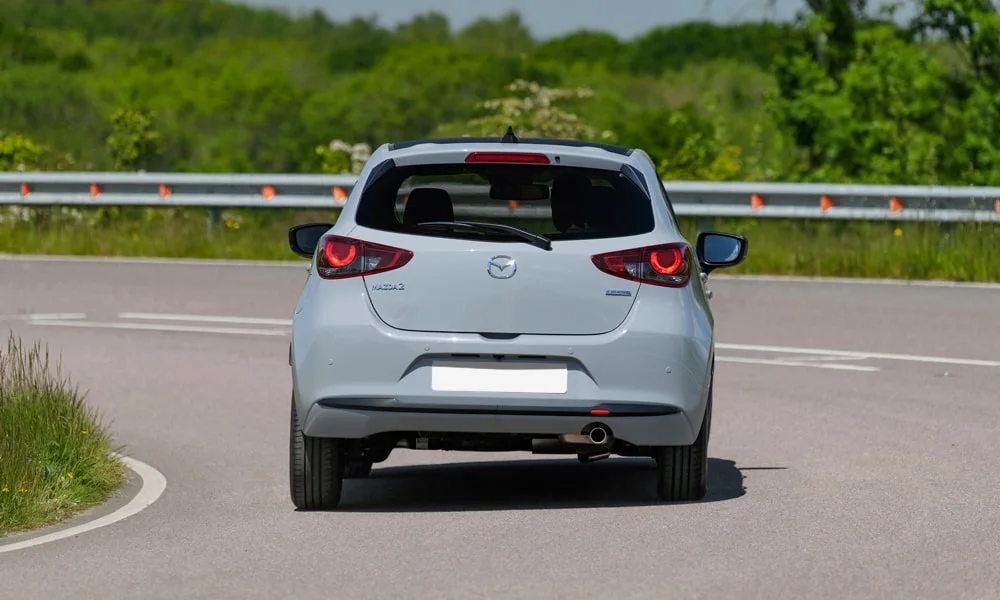 Фото Mazda 2 (2024) — вид сзади, фото 6. Графика фонарей, бампер и оформление пятой двери. Светодиодная полоса или раздельные секции — задняя оптика стала главным украшением кормы Mazda 2 (2024) — вид сзади, фото 6