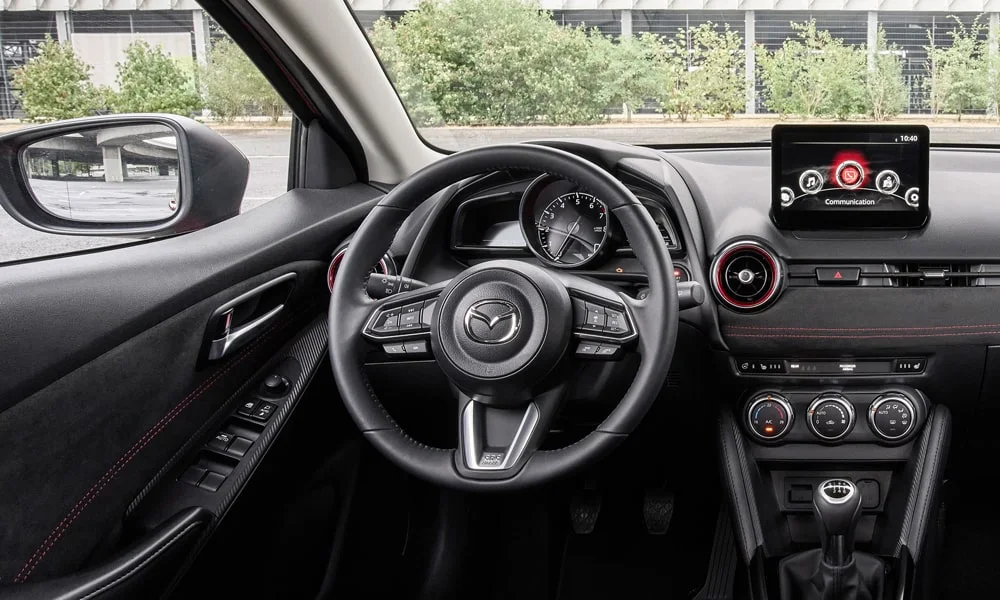 Фото Mazda 2 (2024) — руль. Обшивка обода и компоновка спиц крупным планом. Обогрев обода — опция, которую оценят зимой Mazda 2 (2024) — руль