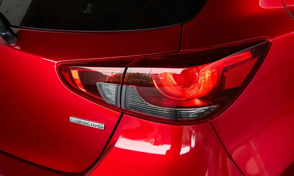 Фото Mazda 2 (2024) — задние фонари. Графика секций крупным планом — ночная подпись модели Mazda 2 (2024) — задние фонари