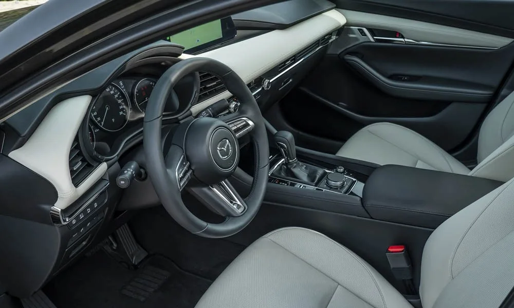 Фото Mazda 3 — передняя панель, фото 3. Архитектура передней панели: ярусы, вставки и консоль в светло-серой гамме. Мягкие материалы верхнего яруса и вставки задают уровень интерьера Mazda 3 — передняя панель, фото 3