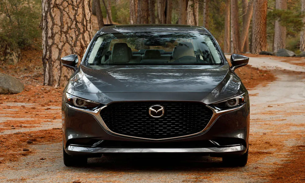 Фото Mazda 3 — вид спереди, фото 16. Серый кузов, строгая симметрия оптики — базовый ракурс знакомства с дизайном Mazda 3 — вид спереди, фото 16