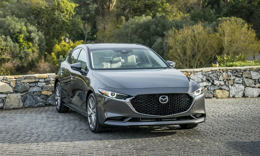 Фото Mazda 3 — вид спереди, фото 19. Кузов в сером цвете: рисунок оптики и решётки задаёт узнаваемое «лицо» модели Mazda 3 — вид спереди, фото 19