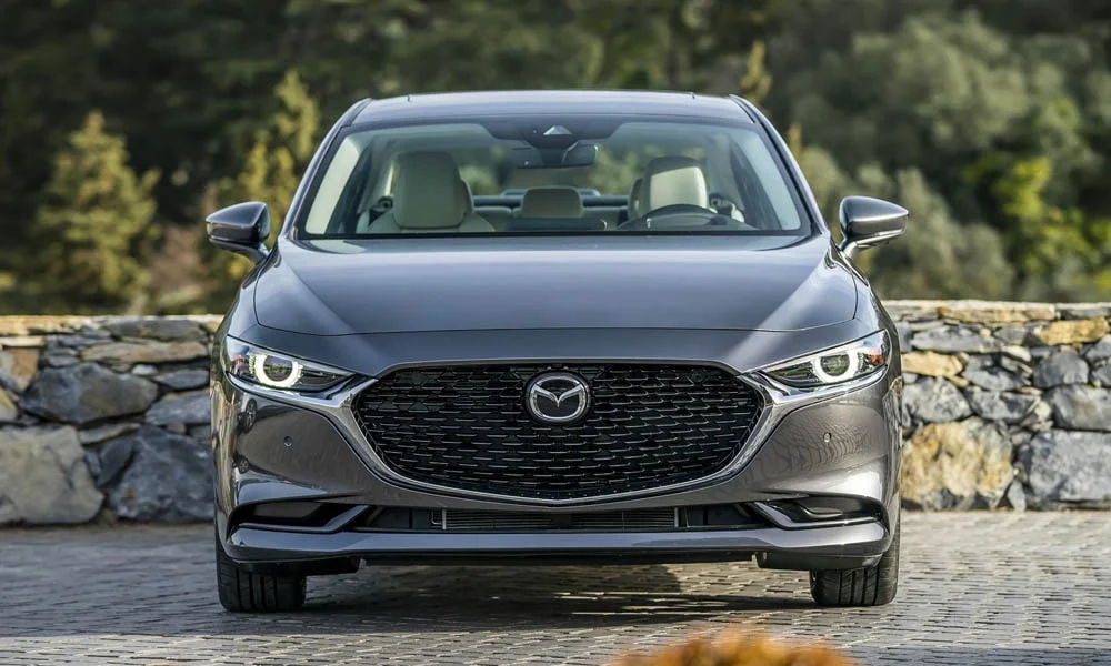 Фото Mazda 3 — вид спереди, фото 20. Кузов в сером цвете: рисунок оптики и решётки задаёт узнаваемое «лицо» модели Mazda 3 — вид спереди, фото 20