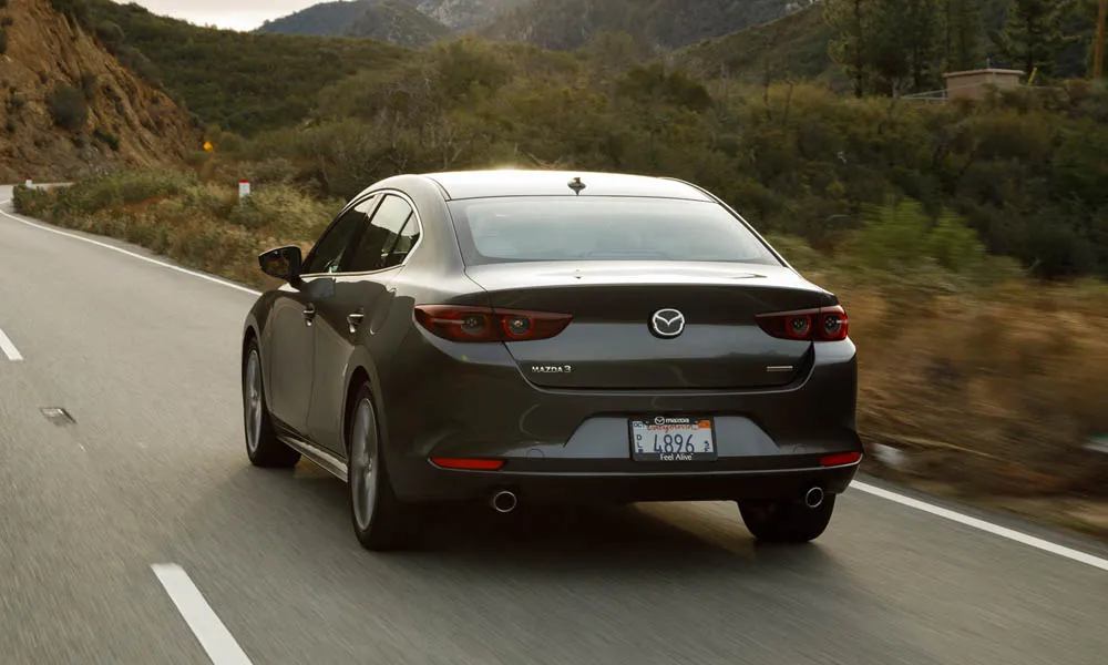 Фото Mazda 3 — вид сзади, фото 13. Корма в сером цвете: графика фонарей и пластика пятой двери. Насадки выхлопа или их имитация внизу бампера различают версии Mazda 3 — вид сзади, фото 13