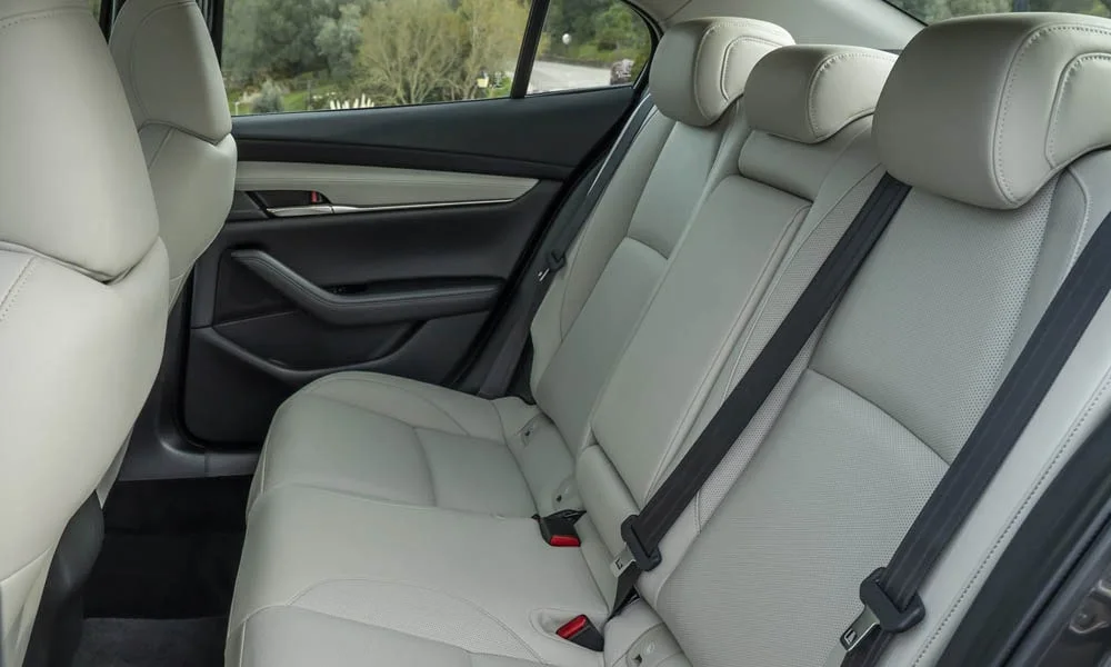Фото Mazda 3 — задние сиденья, фото 2. Посадка второго ряда: подголовники и подлокотник. Спинки складываются под длинные грузы у большинства версий Mazda 3 — задние сиденья, фото 2