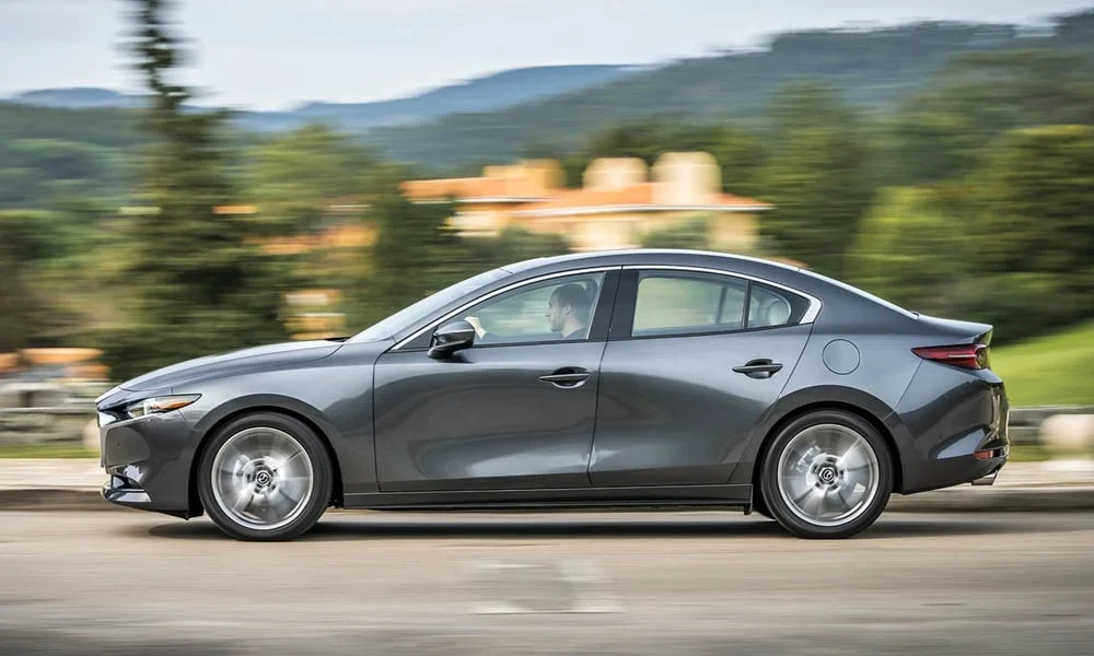 Фото Mazda 3 — вид сбоку, фото 5. Профиль кузова: колёсная база, свесы и линия остекления. Хромированные или чёрные молдинги окон отличают комплектации Mazda 3 — вид сбоку, фото 5