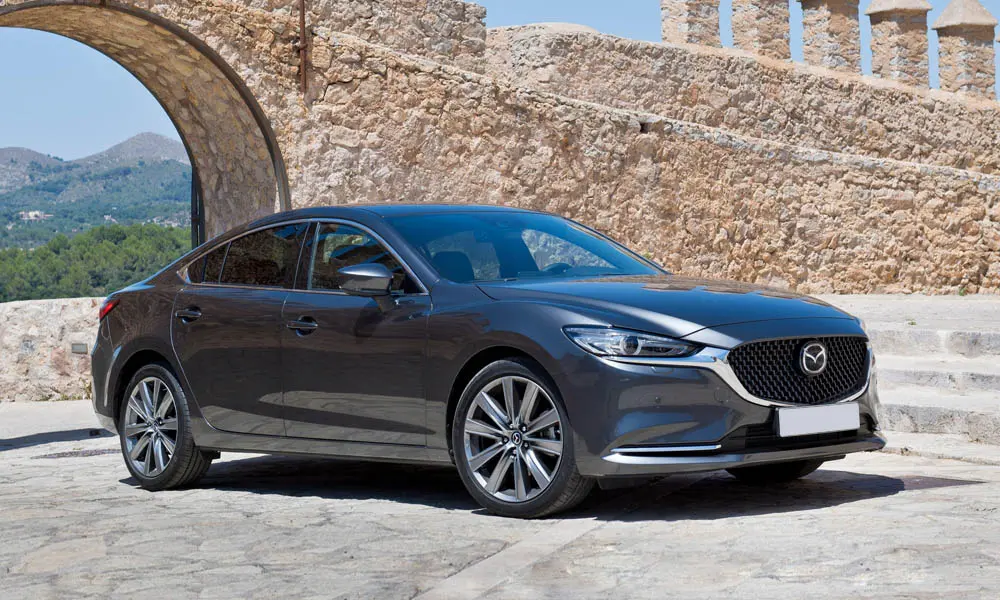 Фото Mazda 6 — вид спереди, фото 6. Серый кузов, строгая симметрия оптики — базовый ракурс знакомства с дизайном. Дневные ходовые огни включаются автоматически с запуском Mazda 6 — вид спереди, фото 6
