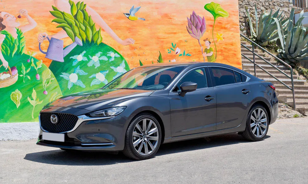 Фото Mazda 6 — вид спереди, фото 9. Анфас: пропорции капота, посадка кузова и графика ходовых огней. Рисунок ходовых огней — подпись модели, по нему её узнают в потоке Mazda 6 — вид спереди, фото 9
