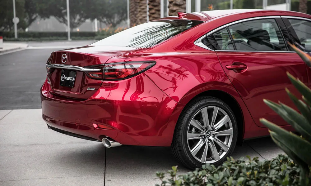 Фото Mazda 6 — вид сзади, фото 3. Корма в красном цвете: графика фонарей и пластика пятой двери. Светодиодная полоса или раздельные секции — задняя оптика стала главным украшением кормы Mazda 6 — вид сзади, фото 3