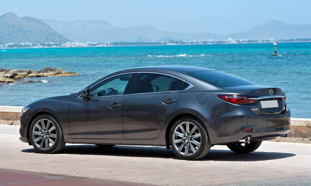 Фото Mazda 6 — вид сзади, фото 5. Линия крыши, стойки и задняя дверь в сером исполнении. Насадки выхлопа или их имитация внизу бампера различают версии Mazda 6 — вид сзади, фото 5