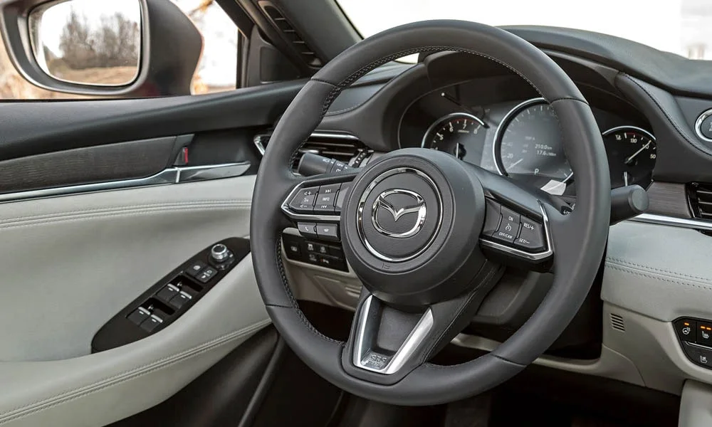 Фото Mazda 6 — руль. Обшивка обода и компоновка спиц крупным планом. Обогрев обода — опция, которую оценят зимой Mazda 6 — руль