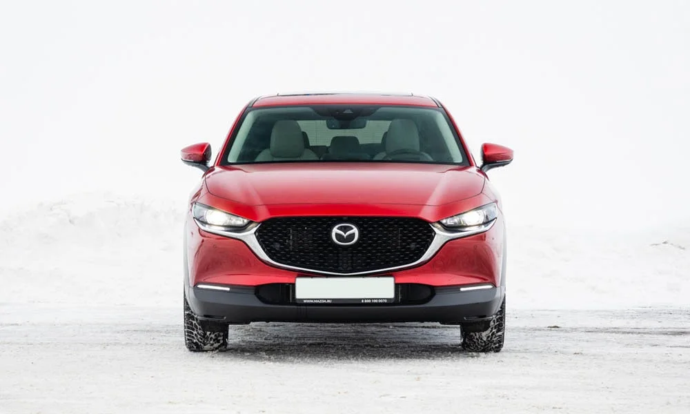 Фото Mazda CX-30 — вид спереди, фото 3. Кузов в красном цвете: рисунок оптики и решётки задаёт узнаваемое «лицо» модели Mazda CX-30 — вид спереди, фото 3