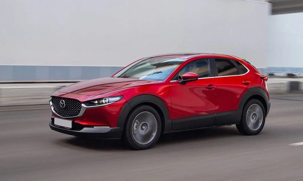 Фото Mazda CX-30 — вид спереди, фото 6. Кузов в красном цвете: рисунок оптики и решётки задаёт узнаваемое «лицо» модели Mazda CX-30 — вид спереди, фото 6