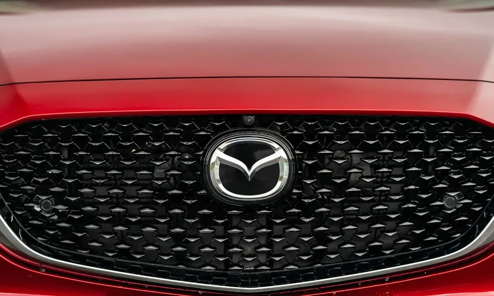Фото Mazda CX-30 — решётка радиатора. Рисунок решётки: сетка, ламели или глухая панель у электроверсий. Активные жалюзи за решёткой закрываются на трассе ради аэродинамики — есть у ряда моделей Mazda CX-30 — решётка радиатора