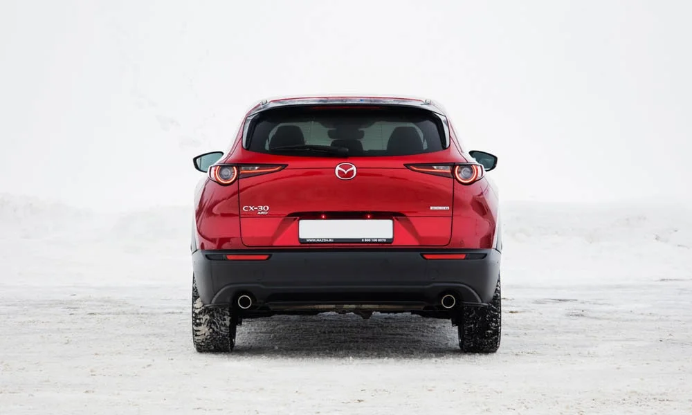 Фото Mazda CX-30 — вид сзади, фото 2. Красный кузов сзади — фонари и бампер определяют ночной образ модели. Светодиодная полоса или раздельные секции — задняя оптика стала главным украшением кормы Mazda CX-30 — вид сзади, фото 2