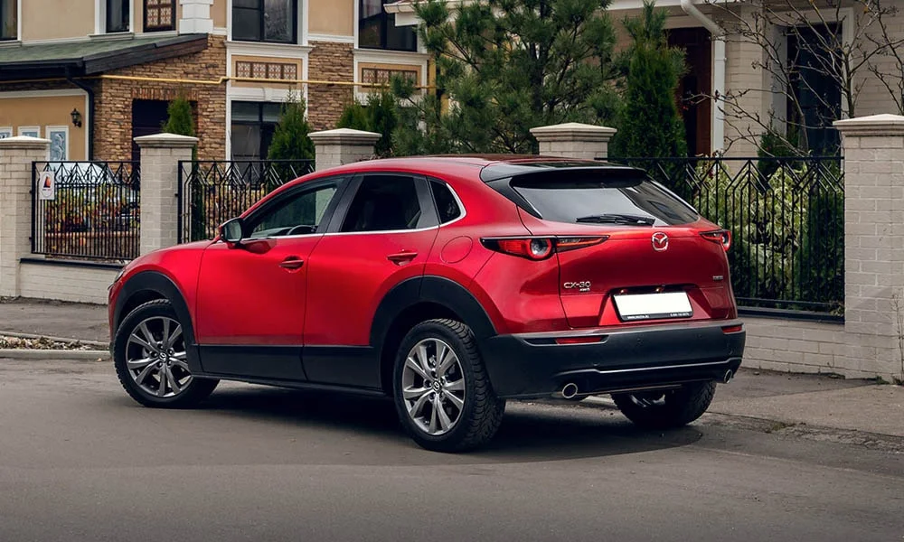 Фото Mazda CX-30 — вид сзади, фото 3. Линия крыши, стойки и задняя дверь в красном исполнении. Насадки выхлопа или их имитация внизу бампера различают версии Mazda CX-30 — вид сзади, фото 3