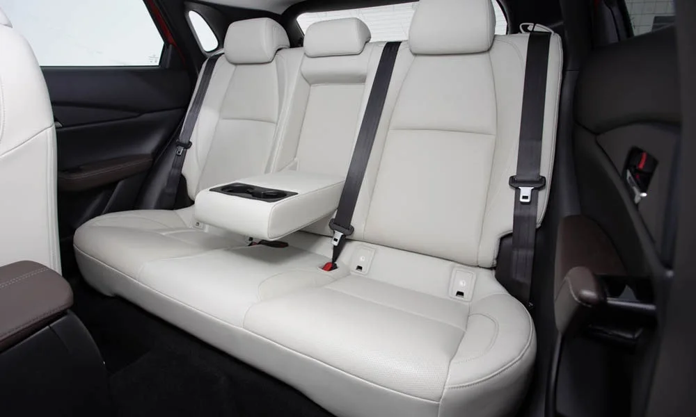 Фото Mazda CX-30 — задние сиденья, фото 3. Посадка второго ряда: подголовники и подлокотник. Крепления ISOFIX для детских кресел — в основании спинки Mazda CX-30 — задние сиденья, фото 3