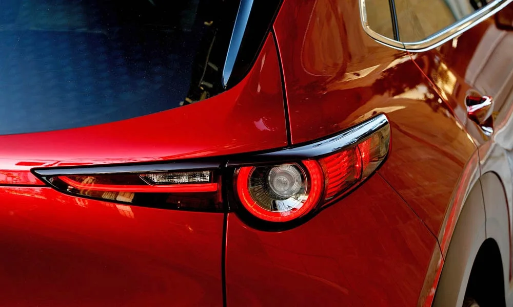 Фото Mazda CX-30 — задние фонари. Рассеиватель фонаря вблизи: компоновка секций габарита, стопа и поворотника. Динамические поворотники с бегущей индикацией встречаются в старших комплектациях Mazda CX-30 — задние фонари