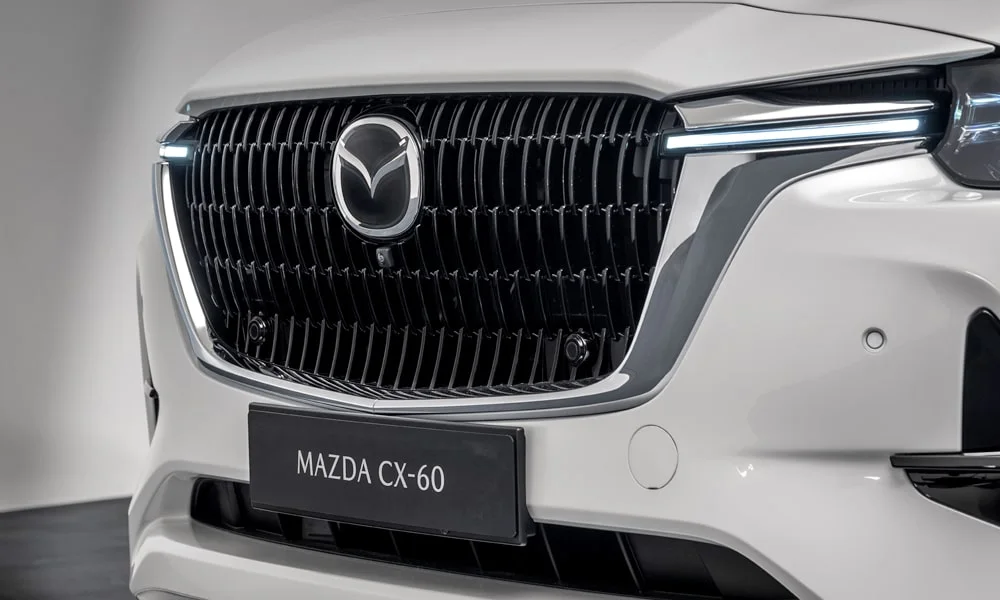 Фото Mazda CX-60 (2024) — решётка радиатора. Фирменный рисунок облицовки — визитная карточка марки Mazda CX-60 (2024) — решётка радиатора