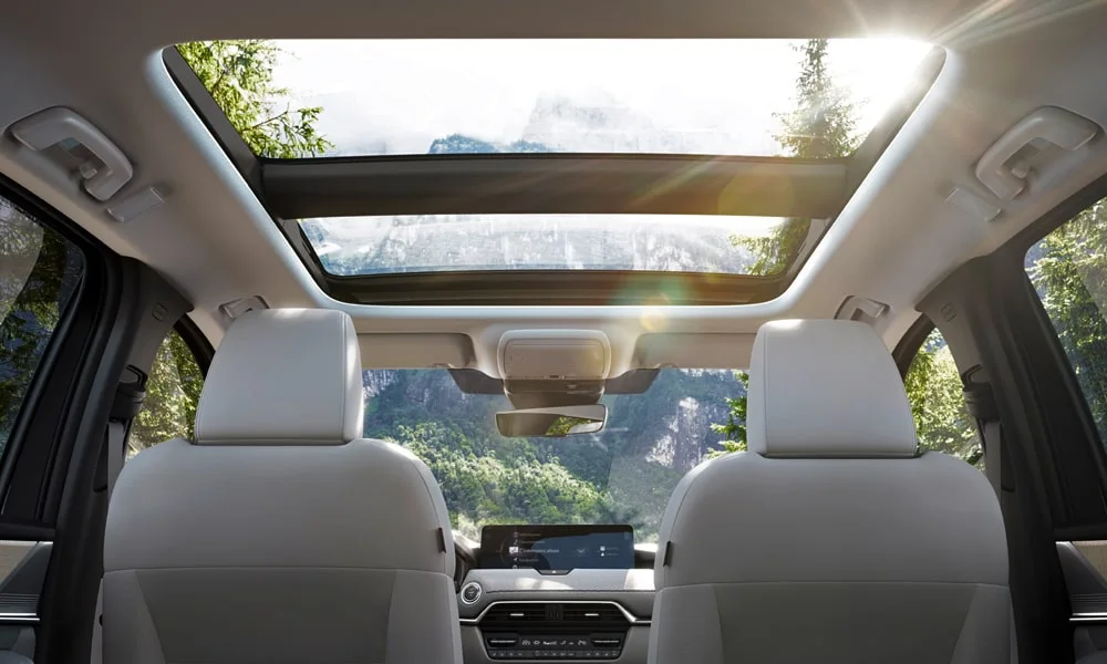 Фото Mazda CX-60 (2024) — панорамная крыша. Вид на остекление крыши из салона. Люк с функцией проветривания приподнимается задней кромкой Mazda CX-60 (2024) — панорамная крыша
