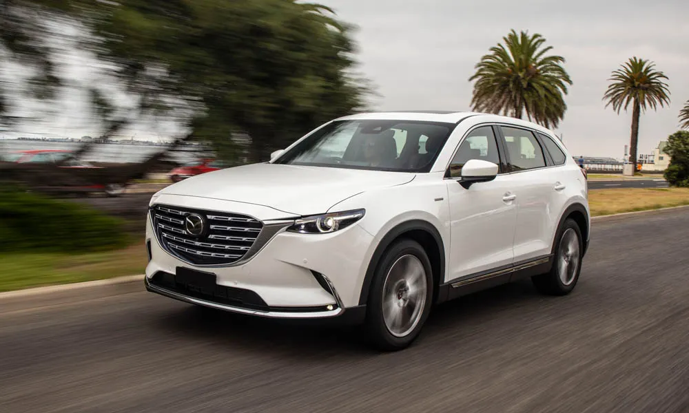 Фото Mazda CX-9 — вид спереди, фото 4. Оптика, решётка и бампер — первое впечатление о модели. Дневные ходовые огни включаются автоматически с запуском Mazda CX-9 — вид спереди, фото 4