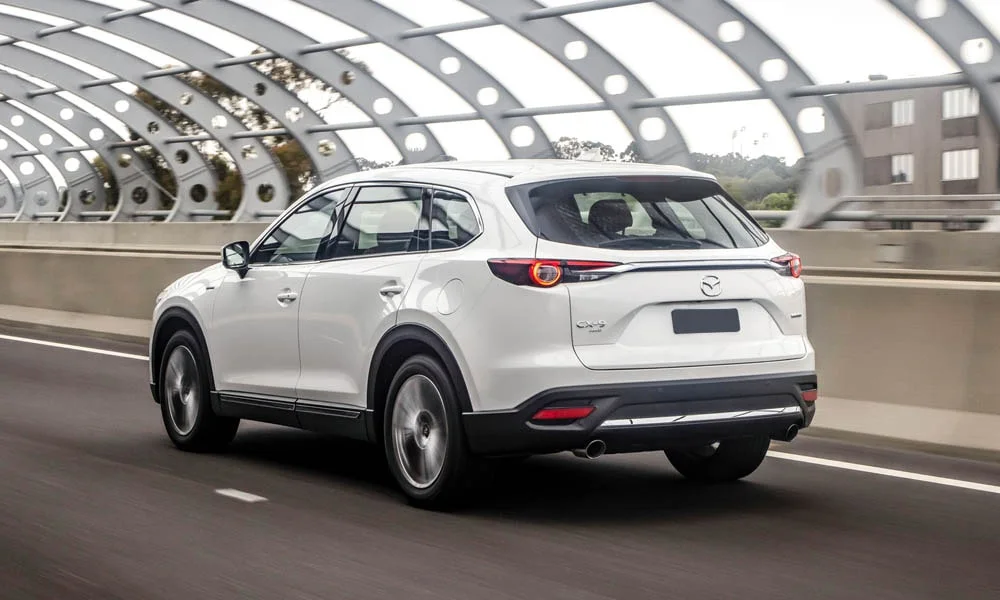 Фото Mazda CX-9 — вид сзади, фото 4. Белый кузов сзади — фонари и бампер определяют ночной образ модели. Насадки выхлопа или их имитация внизу бампера различают версии Mazda CX-9 — вид сзади, фото 4
