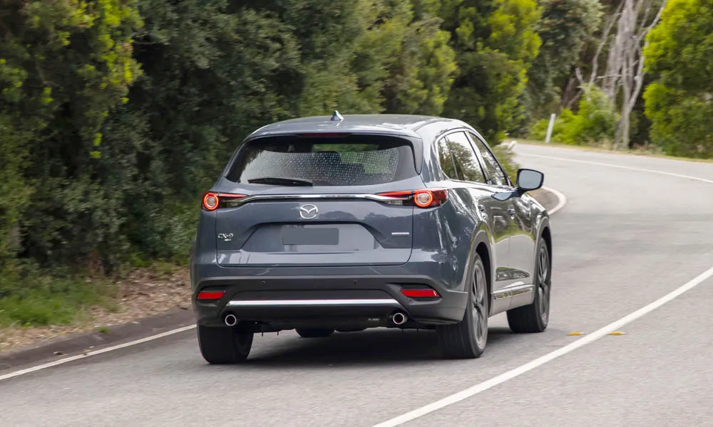 Фото Mazda CX-9 — вид сзади, фото 8. Корма в сером цвете: графика фонарей и пластика пятой двери. Насадки выхлопа или их имитация внизу бампера различают версии Mazda CX-9 — вид сзади, фото 8