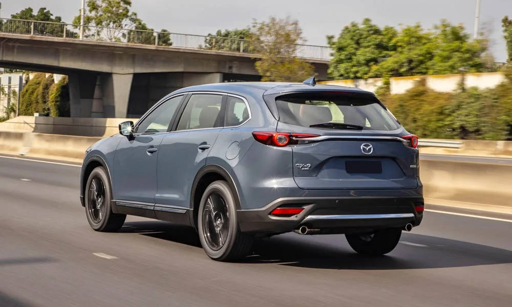 Фото Mazda CX-9 — вид сзади, фото 9. Корма в сером цвете: графика фонарей и пластика пятой двери. Светодиодная полоса или раздельные секции — задняя оптика стала главным украшением кормы Mazda CX-9 — вид сзади, фото 9