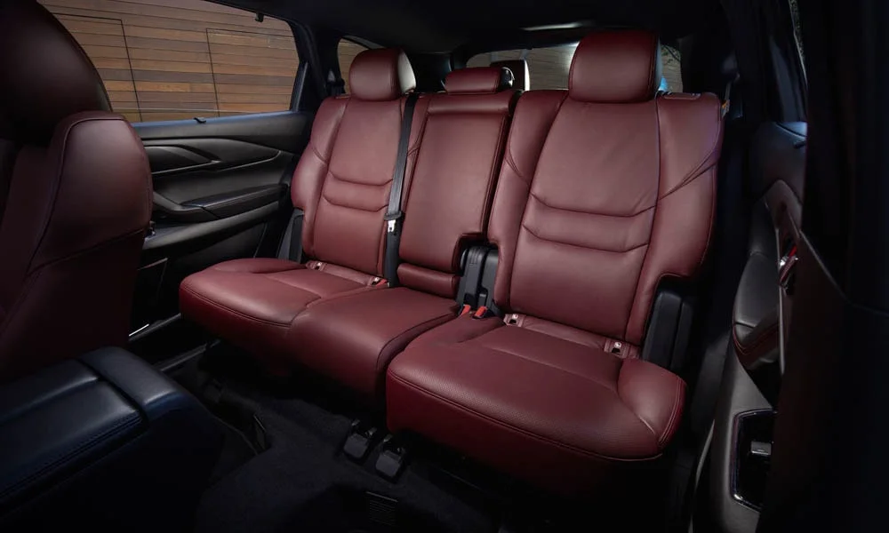 Фото Mazda CX-9 — задние сиденья. Задний диван в гладкой коже: посадка и центральный подлокотник. Крепления ISOFIX для детских кресел — в основании спинки Mazda CX-9 — задние сиденья