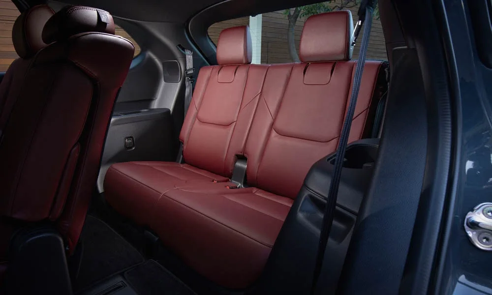 Фото Mazda CX-9 — задние сиденья, фото 2. Задний диван в гладкой коже: посадка и центральный подлокотник. Крепления ISOFIX для детских кресел — в основании спинки Mazda CX-9 — задние сиденья, фото 2