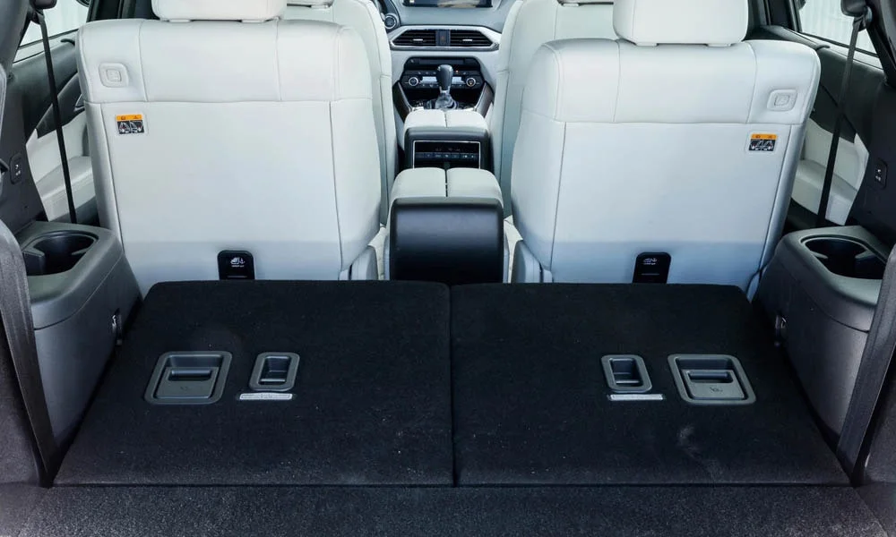 Фото Mazda CX-9 — задние сиденья, фото 6. Посадка второго ряда: подголовники и подлокотник. Крепления ISOFIX для детских кресел — в основании спинки Mazda CX-9 — задние сиденья, фото 6